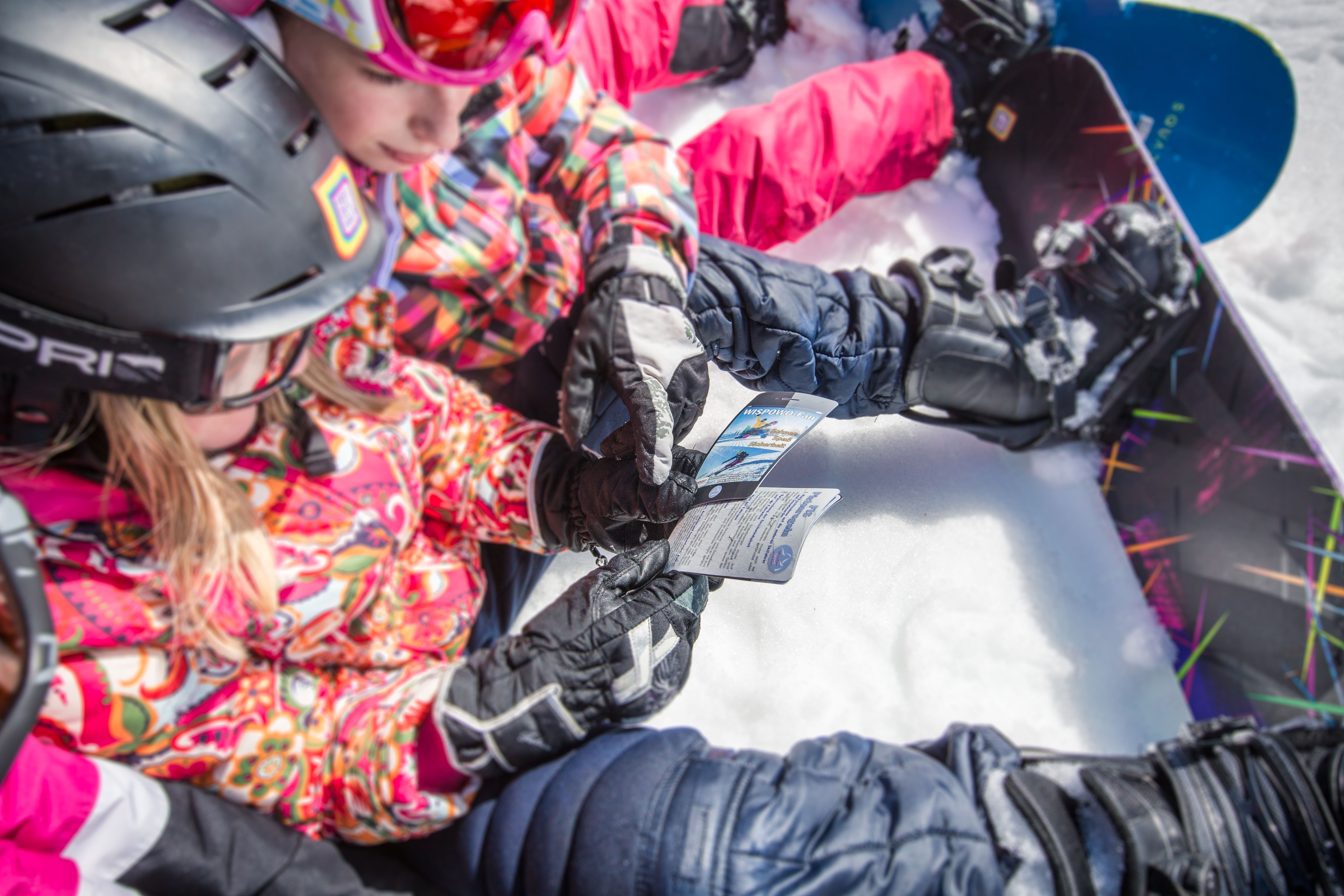 sitzende Kinder mit Snowboard 